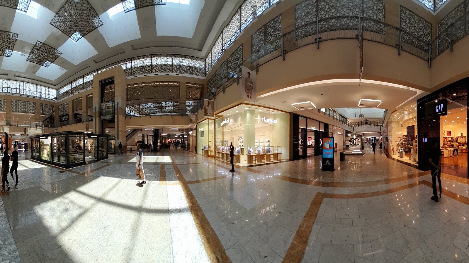 Bright shopping mall walkway with storefronts in Dubai